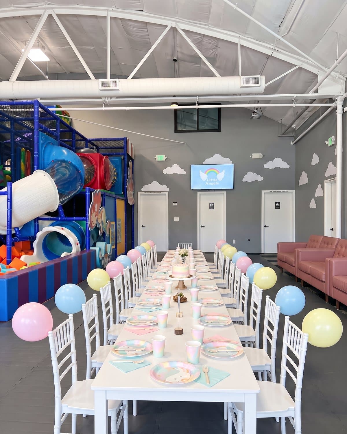 The party table set with pastel plates, cups and a cake stand in the party room